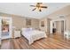 Bright main bedroom with wood-look floors, a ceiling fan, and backyard patio access at 38771 N Dena Dr, San Tan Valley, AZ 85140
