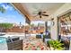 Relaxing covered patio featuring comfortable seating, ceiling fan, and outdoor kitchen area at 38771 N Dena Dr, San Tan Valley, AZ 85140