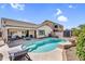 Inviting pool area with blue pool, patio seating, and well-maintained landscaping, perfect for outdoor relaxation at 38771 N Dena Dr, San Tan Valley, AZ 85140