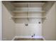 Functional laundry room offers built-in shelving and utility connections for efficient organization at 3897 E Douglas Loop, Gilbert, AZ 85234