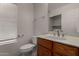 Cozy half bath featuring a wood vanity, sink, toilet, and window for natural light at 4644 W Havasupai Dr, Glendale, AZ 85308