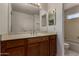 Bathroom vanity with wood cabinets, a neutral countertop, and a large mirror at 4644 W Havasupai Dr, Glendale, AZ 85308