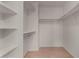 Walk-in closet with white shelving and light wood floors at 4644 W Havasupai Dr, Glendale, AZ 85308
