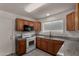 Efficient kitchen with wood cabinets, granite counters, and modern white appliances at 4644 W Havasupai Dr, Glendale, AZ 85308