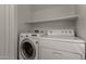 Laundry room with front loading washing machine, top load dryer and floating shelf at 4644 W Havasupai Dr, Glendale, AZ 85308