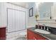 A bathroom with white wainscotting, black countertops and a red vanity at 4710 N 33Rd Pl, Phoenix, AZ 85018