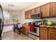 Cozy eat-in kitchen with wood cabinets, tile floors, and stainless steel appliances at 5654 W Vineyard Rd, Laveen, AZ 85339