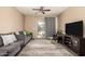 Cozy living room featuring a comfortable gray sofa, sliding glass doors, and a ceiling fan at 5654 W Vineyard Rd, Laveen, AZ 85339