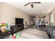 Open-concept living space with dark vinyl floors, ceiling fan, and seamless access to dining area at 5654 W Vineyard Rd, Laveen, AZ 85339