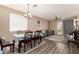Open-concept dining and living area featuring vinyl floors, chandelier, and bright natural light at 5654 W Vineyard Rd, Laveen, AZ 85339