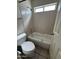 Bathroom with a tub shower combo with neutral tile and white toilet at 6407 W Madras Ln, Glendale, AZ 85306