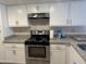 Close up of the kitchen with stainless steel appliances, modern cabinets, and stone countertops at 6407 W Madras Ln, Glendale, AZ 85306