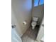 Small half bathroom featuring tile flooring and a toilet with a small window for natural light at 6407 W Madras Ln, Glendale, AZ 85306