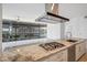 Close-up of a kitchen island featuring granite countertops, a gas cooktop, and stainless steel appliances at 7180 E Kierland Blvd # 507, Scottsdale, AZ 85254