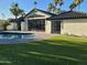 Back exterior with a sparkling pool and a large glass door that allows for an abundance of natural light at 7724 E Charter Oak Rd, Scottsdale, AZ 85260