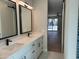 Bright bathroom features a double sink vanity with white cabinets, black fixtures, and modern mirrors at 7724 E Charter Oak Rd, Scottsdale, AZ 85260