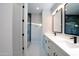 Stylish bathroom showcasing dual vanities, modern fixtures, and a glass-enclosed shower with blue tiling at 7724 E Charter Oak Rd, Scottsdale, AZ 85260
