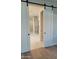View through sliding barn doors to a well-appointed bathroom with glass shower and modern fixtures at 7724 E Charter Oak Rd, Scottsdale, AZ 85260