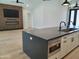 Kitchen island featuring a black faucet, hardwood flooring, and modern cabinets at 7724 E Charter Oak Rd, Scottsdale, AZ 85260