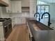 Kitchen island with a modern sink, range, and sleek white cabinetry at 7724 E Charter Oak Rd, Scottsdale, AZ 85260
