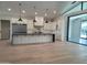 Open concept kitchen and living space featuring hardwood flooring, an island, and white cabinetry at 7724 E Charter Oak Rd, Scottsdale, AZ 85260