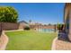 Lush backyard featuring green lawn and a refreshing swimming pool at 9074 W Runion Dr, Peoria, AZ 85382