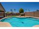 Sparkling pool surrounded by lush landscaping and a secure fence, perfect for relaxation and entertaining at 9074 W Runion Dr, Peoria, AZ 85382