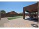 Landscaped backyard featuring an artificial lawn, stone pavers, and covered patio at 9337 W Medlock Dr, Glendale, AZ 85305