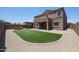 Large backyard featuring artificial grass, a covered patio, and a basketball hoop at 9337 W Medlock Dr, Glendale, AZ 85305