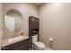 Cozy powder room features a granite countertop vanity and a matching storage cabinet above the toilet at 9337 W Medlock Dr, Glendale, AZ 85305