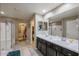 Well-lit bathroom featuring double sinks, a walk-in shower, and tile flooring at 9337 W Medlock Dr, Glendale, AZ 85305
