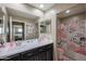 Well-lit bathroom featuring double sinks and a shower/tub combination with pink floral shower curtain at 9337 W Medlock Dr, Glendale, AZ 85305