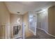 Bright hallway with neutral walls, white railings, and a modern chandelier at 9337 W Medlock Dr, Glendale, AZ 85305