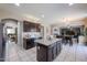 Spacious kitchen features granite countertops, stainless appliances, an island, and connects to dining and living areas at 9337 W Medlock Dr, Glendale, AZ 85305