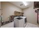 Functional laundry room with washer, dryer, utility sink, and storage shelves at 9337 W Medlock Dr, Glendale, AZ 85305