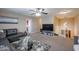 Spacious living room with TV, plush gray sofa, glass coffee table, and carpet at 9337 W Medlock Dr, Glendale, AZ 85305