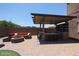 This outdoor kitchen offers bar seating and an entertainment space, perfect for hosting gatherings in your backyard at 9337 W Medlock Dr, Glendale, AZ 85305