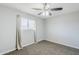 A simple bedroom with neutral walls, carpet, ceiling fan, and a window with light colored curtains at 1066 E 7Th Pl, Mesa, AZ 85203