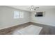 A cozy bedroom featuring wood-look flooring with a decorative tile inset and a modern ceiling fan at 1066 E 7Th Pl, Mesa, AZ 85203