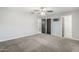 Spacious bedroom featuring neutral carpet, a ceiling fan, and multiple access doors at 1066 E 7Th Pl, Mesa, AZ 85203