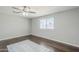 Bright bedroom with wood-look flooring, a ceiling fan, and a window providing natural light at 1066 E 7Th Pl, Mesa, AZ 85203
