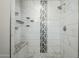 Modern bathroom shower featuring white marble tile, a built-in bench, and sleek fixtures for a spa-like experience at 1066 E 7Th Pl, Mesa, AZ 85203