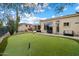 Backyard features lush green lawn, desert landscaping and covered patio seating at 11448 E Blue Sky Dr, Scottsdale, AZ 85262