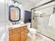 Bathroom featuring vanity with granite countertop, framed mirror, and a glass-enclosed shower at 12770 W Alvarado Rd, Avondale, AZ 85392