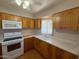 Traditional kitchen with wood cabinets, white appliances and composite countertops at 131 N Higley Rd # 215, Mesa, AZ 85205