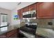 Kitchen area showcasing granite countertops, wood cabinets, and stainless-steel appliances at 1454 E Calle De Arcos --, Tempe, AZ 85284