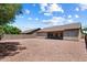 A spacious backyard featuring a covered patio and stone ground cover, creating a serene outdoor retreat at 14821 W Honeysuckle Ln, Surprise, AZ 85374