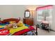 Bright bedroom featuring a colorful bed, a dresser, and a vintage standing mirror at 14821 W Honeysuckle Ln, Surprise, AZ 85374