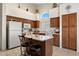 Charming kitchen featuring white appliances, tiled floors, an island with seating, and abundant natural light at 14821 W Honeysuckle Ln, Surprise, AZ 85374