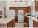 Functional kitchen with white appliances, ample cabinet space, and tile flooring, providing a clean and efficient cooking environment at 14821 W Honeysuckle Ln, Surprise, AZ 85374